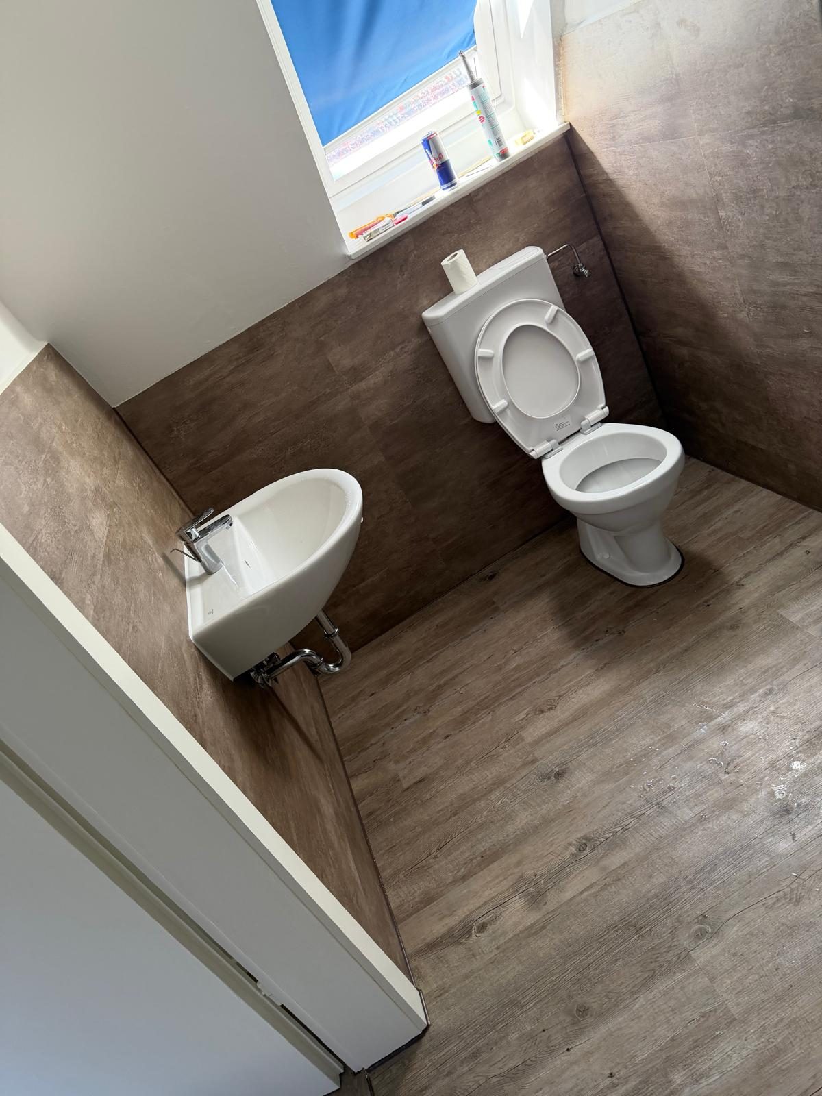 Nachher – fertig saniertes Bad mit neuem Boden, WC und Waschbecken